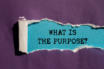 What is the purpose message written on ripped torn purple paper on blue background. Conceptual what...