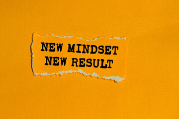New mindset new result message written on ripped torn orange paper piece on orange background....