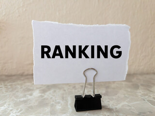 Ranking message written on ripped torn white paper piece on wall background. Conceptual ranking...