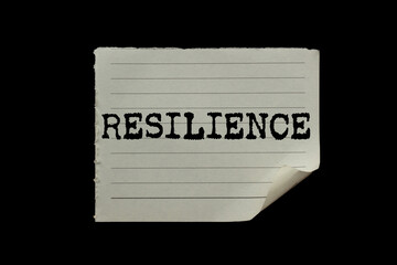 Resilience message written on ripped torn paper piece on black background. Conceptual resilience...