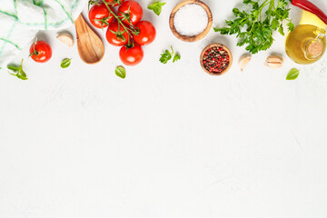 Spices, herbs and vegetables with olive oil on white kitchen table.
