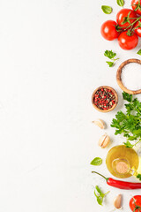 Spices, herbs and vegetables with olive oil on white kitchen table.