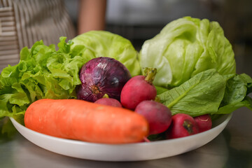 Ingredients for a fresh vegetable and egg sandwich are placed on a table in a modern kitchen.