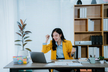 Young beautiful asian businesswoman using calculator while working with financial data and laptop...