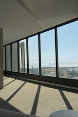 Modern panoramic windows with ocean view and sunlight reflections. Bright minimalist interior with...