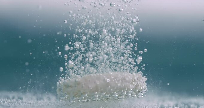 Extreme Close-up effervescent tablet, pill bubbling underwater. Shot on super slow motion camera 1000 fps.