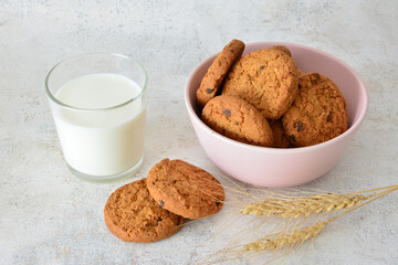 a bowl of freshly baked oatmeal Cookies and a glass of Milk