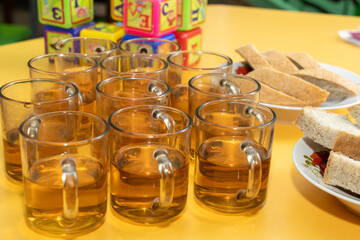 Delightful gathering with tea and snacks on a vibrant yellow table at a community center