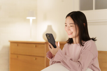 夜中にスマホを見る女性