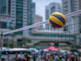 Vibrant volleyball in mid-air above a net, set against a bustling beach scene with tall buildings and colorful umbrellas, capturing the essence of summer sports and leisure activities