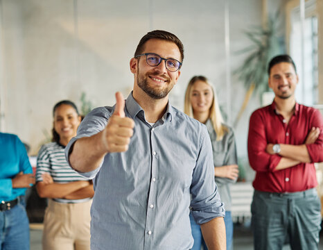 Portrait of a group of young business people having a meeting in the office. Teamwork and success concept, portrait of a smart young businessman with a thumb up approval sign