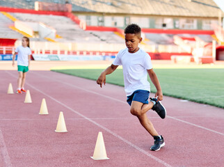 Children running on track at the stadium, practice during sports class in school training Little...