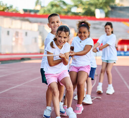 Children pulling a rope at the stadium, practice during sports class in school training, little fit boys and girls in sportswear training as athletes outdoor. Concept of sport, fitness and achievement © Lumos sp