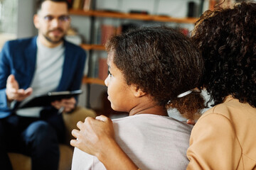 Mother with her teenage daughter at meeting with social worker, psychologist discussing mental...