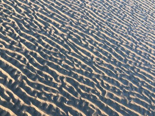 gray beach wavy sand ripples dune texture wallpaper pattern background close-up