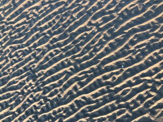 gray beach wavy sand ripples dune texture wallpaper pattern background close-up
