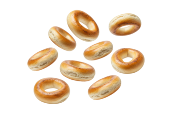 A collection of bagels scattered on a black background with varying orientations and lighting conditions