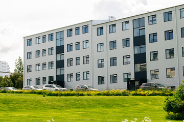Modern apartment building in Reykjavik with parked cars and green surroundings