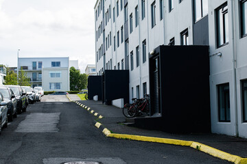 Naklejka premium Urban street with parked cars and buildings in Reykjavik, Iceland on a cloudy day