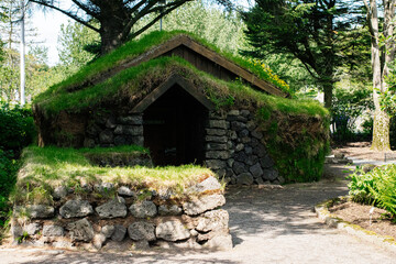 Grass roof stone house in Reykjavik surrounded by lush greenery
