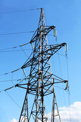 Overhead power line support against blue sky. Power transmission line.