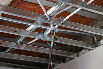 
Electrical installation on a ceiling with a metal structure and exposed cables