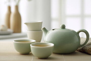 A serene Asian tea ceremony scene, featuring a beautifully arranged tea set with delicate porcelain cups and a steaming teapot.