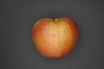Fresh red apple resting on a dark background invites taste and freshness, showcasing its vibrant color and smooth texture with a hint of shine