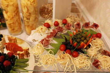 Beautiful, delicious buffet table with canapes, sausages, ham, cheese
