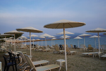 Serene seaside retreat with elegant umbrellas dotting sandy shores under a tranquil sky during golden hour on a peaceful afternoon