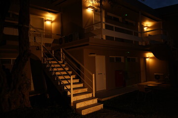 Soft golden lights illuminate a cozy staircase leading to a quiet retreat on a serene night filled with tranquility and calmness