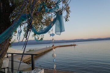 Waves gently shimmer at sunset near a tranquil lake adorned with handmade decorations, creating a serene escape for wanderers and nature lovers alike