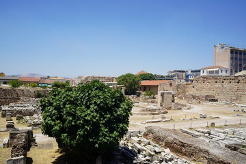 Exploring ancient ruins under a bright blue sky in Greece, where history whispers through the weathered stones and vibrant greenery thrives amidst the remnants of time