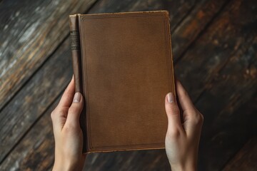 A person is holding a book with a brown cover. The book is open to a blank page. Hands holding book cover mockup.