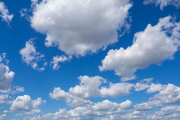 Sky and clouds. White cumulus clouds against blue sky with color gradient. Cloudy weather.
