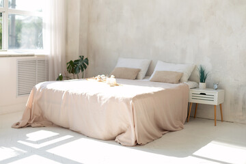 Modern design interior bedroom in simple style. Double bed with white pillows and soft blanket, window with curtains, houseplant and wooden nightstand with decor in skandinavian bedroom. empty space
