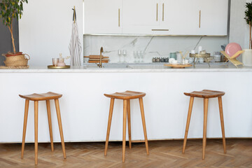 Scandinavian empty classic modern luxury kitchen with wooden bar stools and island. Interior white...