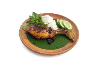 Ayam bakar kecap or Grilled chicken with soy sauce on plate on white background, Indonesian culinary.