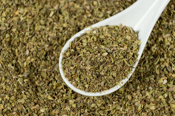Dried Green Oregano Leaves in a Spoon. Natural Cooking Ingredient.