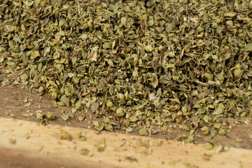 Natural Italian Spice Dried Chopped Oregano on Wooden Macro Background.