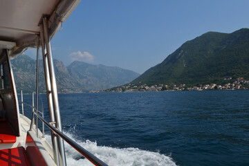 View from a Tourist Boat Cruising the Bay of Kotor, Montenegro, with Mountains and Coastal Towns