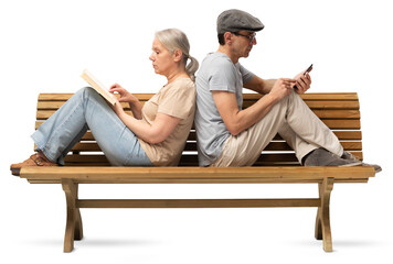Mature couple sitting back to back on a wooden bench, woman reading book and man using smartphone....