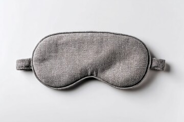 Gray fabric sleep mask on a white surface with band attachments on each side