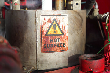Hot surface safety warning sign on the pumping unit machine part. Safety sign and symbol for...