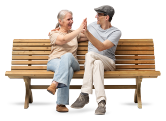 Happy mature couple sitting on a wooden bench, embracing and smiling with joy. A cheerful and affectionate moment together. Studio shot isolated on white background. Both are casually dressed.