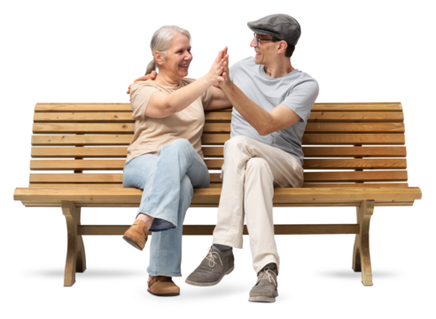 Happy mature couple sitting on a wooden bench, embracing and smiling with joy. A cheerful and affectionate moment together. Studio shot isolated on white background. Both are casually dressed.