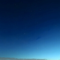 A clear blue sky with a few stars
