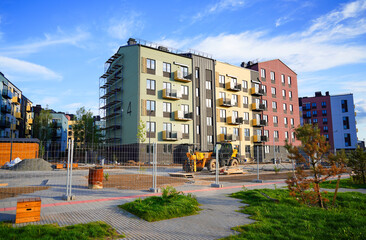 Building construction. Modern Residential condo. Residential Building renovation. Modern condominium with multi-colored facade on construction site. Scaffolding for painting residential building.