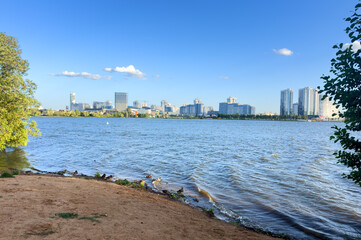 City near lake at sunset. Downtown Minsk and Lake Drozdy. Long Panoramic River Downtown City Skyline. Panarama of City with buildings and  houses on waterfront. buildings and downtown city skyline