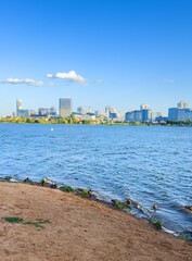City near lake at sunset. Downtown Minsk and Lake Drozdy. Long Panoramic River Downtown City Skyline. Panarama of City with buildings and  houses on waterfront. buildings and downtown city skyline